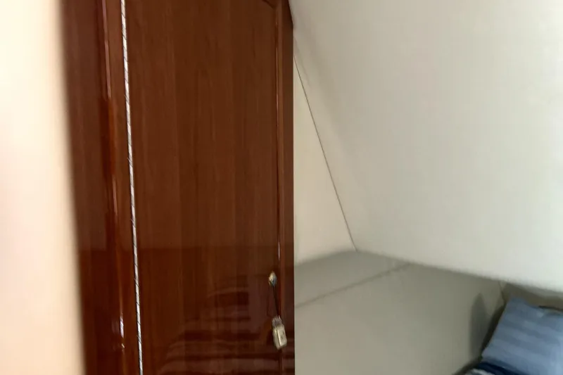 Slide: The Image of Interior cabin of 2004 Wellcraft 47 Excalibur with wooden door and bed. - 36