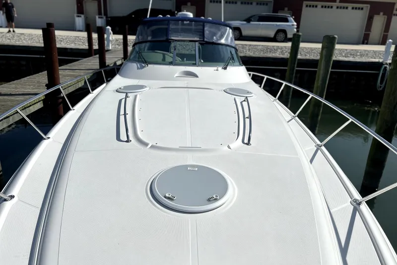 Slide: The Image of 2004 Wellcraft 47 Excalibur boat docked, showcasing sleek deck design and railings. - 4