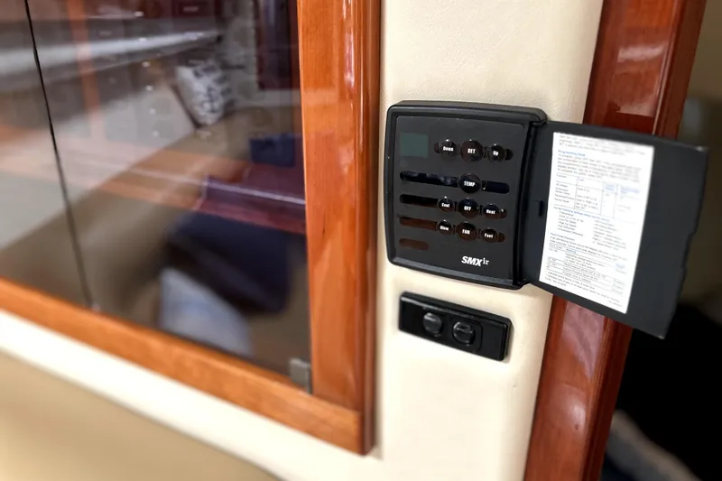 Slide: The Image of Control panel inside 2004 Wellcraft 47 Excalibur boat, featuring wood trim and digital display. - 40