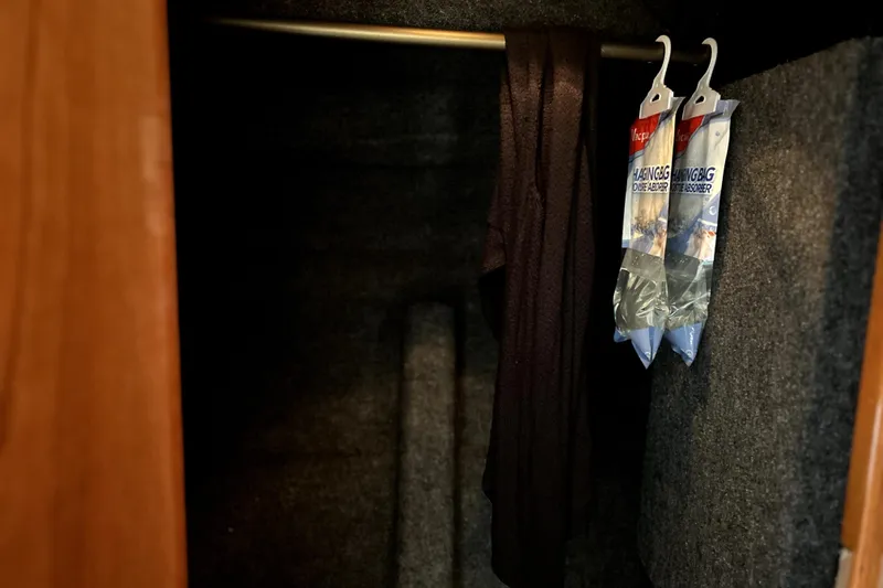 Slide: The Image of Closet interior of 2004 Wellcraft 47 Excalibur with hanging clothes and dehumidifier bags. - 45