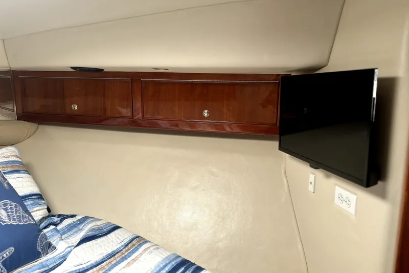 Slide: The Image of Interior of 2004 Wellcraft 47 Excalibur with wooden cabinets and mounted TV. - 47