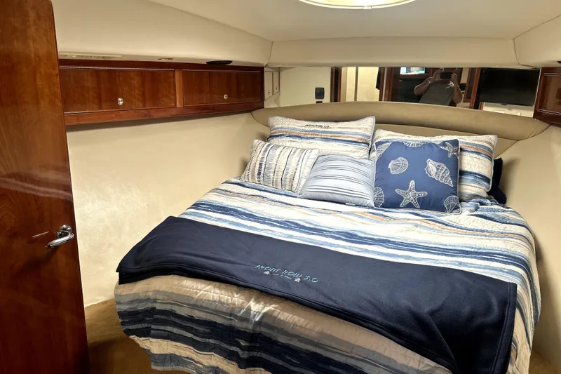 Slide: The Image of Luxurious cabin interior of 2004 Wellcraft 47 Excalibur with cozy bedding and wooden cabinetry. - 48