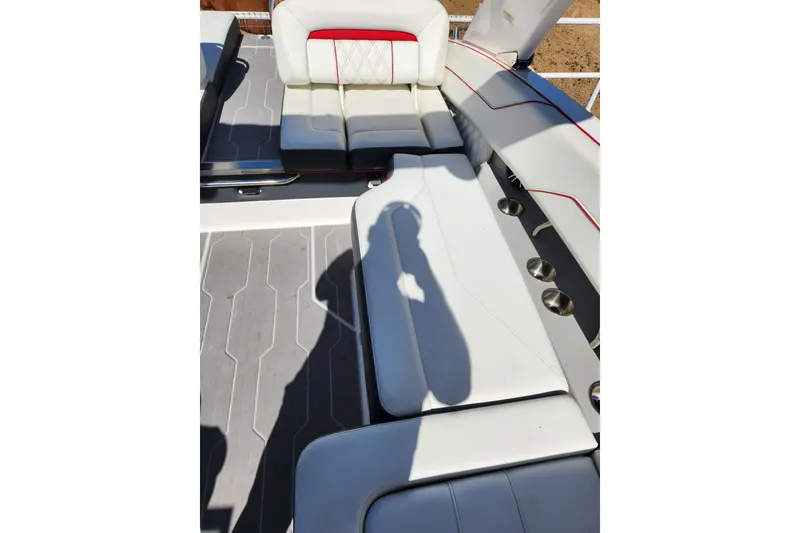 Slide: The Image of 2020 Regal LS4 Surf boat interior with white and red seating, cup holders, and shadow. - 18