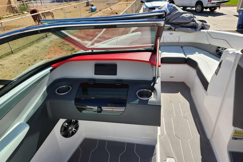 Slide: The Image of 2020 Regal LS4 Surf boat interior with seating, cup holders, and dashboard. - 32