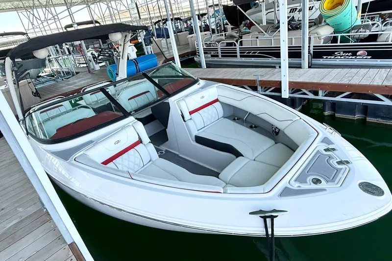 Slide: The Image of 2020 Regal LS4 Surf boat docked, featuring sleek white and red interior design. - 4
