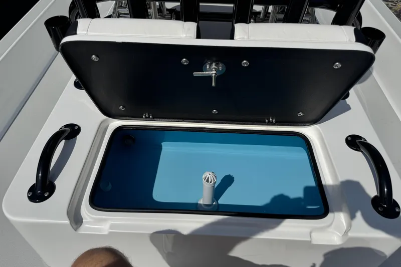 Slide: The Image of Open storage compartment on 2026 SCB R24 boat with blue interior and black handles. - 23