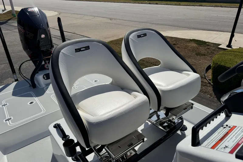 Slide: The Image of 2026 SCB R24 boat with white cushioned seats and powerful outboard motor. - 24