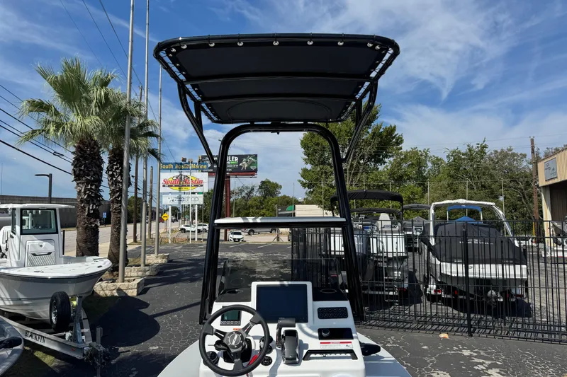 Slide: The Image of 2026 SCB R24 boat with T-top, steering console, and palm trees in a marina setting. - 30