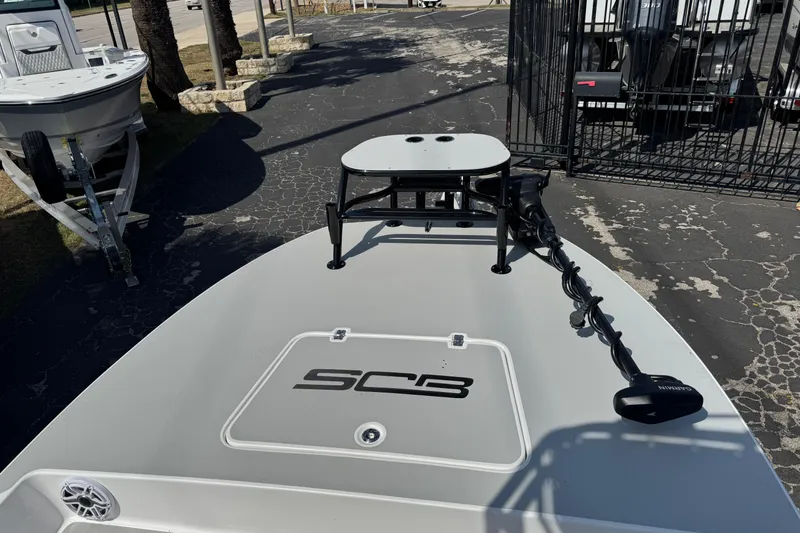 Slide: The Image of 2026 SCB R24 boat deck with trolling motor and logo, parked on pavement. - 35