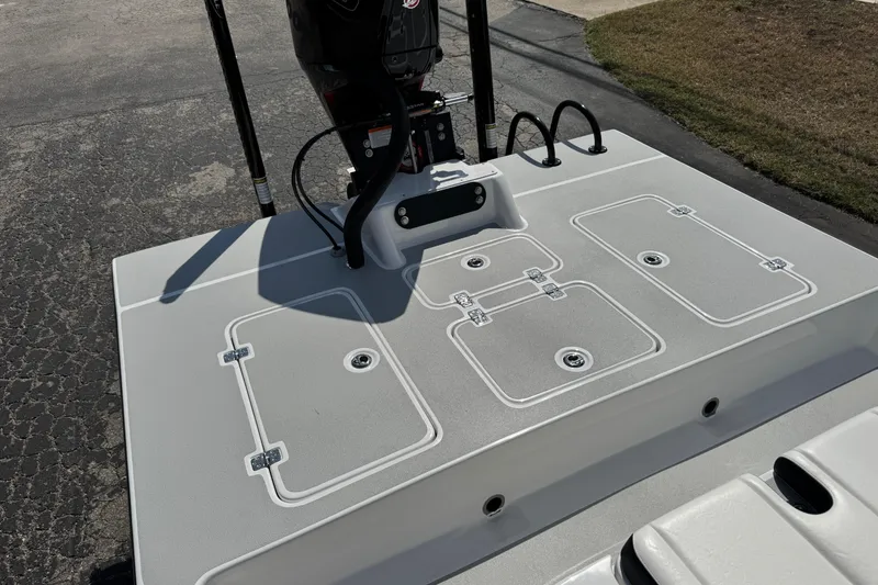 Slide: The Image of 2026 SCB R24 boat deck with storage compartments and motor, parked on pavement. - 39