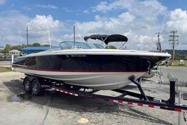 The Image of 2008 Chris-Craft Launch 28 boat on trailer, parked outdoors under a cloudy sky. - 1