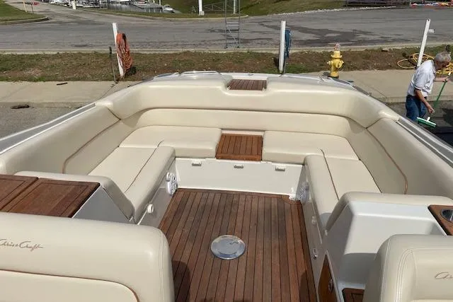Slide: The Image of 2008 Chris-Craft Launch 28 boat interior with beige seating and wooden deck. - 11