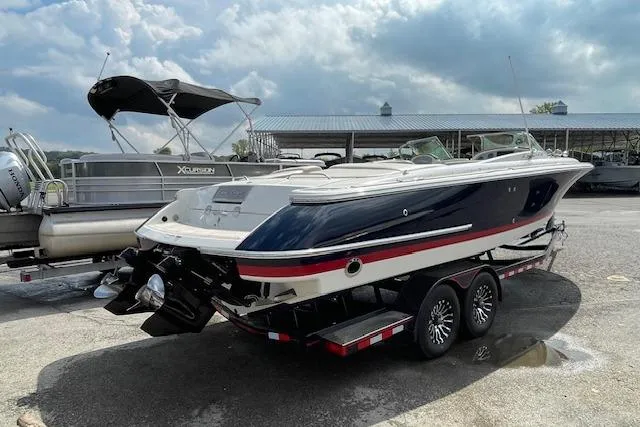 Slide: The Image of 2008 Chris-Craft Launch 28 boat on trailer, parked outdoors under cloudy sky. - 3
