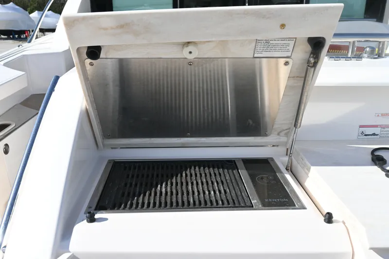 Slide: The Image of 2017 Tiara 44 Coupe boat hull on stands, showcasing sleek design and blue color. - 17