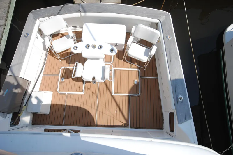 Slide: The Image of 1999 Ocean Yachts 45 Super Sport deck with chairs and table, featuring teak flooring. - 12