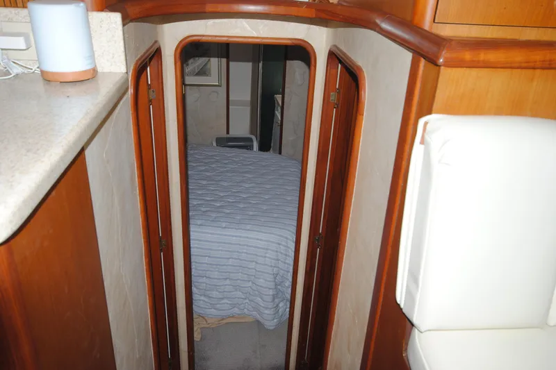 Slide: The Image of Interior view of 1999 Ocean Yachts 45 Super Sport cabin with bed and wooden accents. - 22