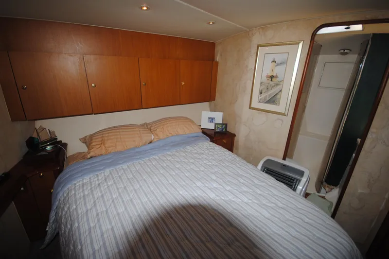 Slide: The Image of Cozy bedroom in 1999 Ocean Yachts 45 Super Sport with wood cabinets and nautical decor. - 28