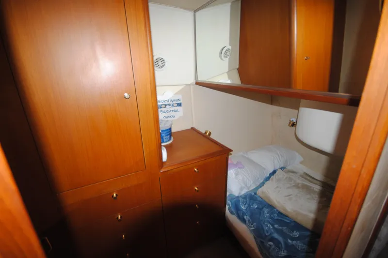Slide: The Image of 1999 Ocean Yachts 45 Super Sport cabin with wooden cabinetry and cozy bedding. - 23
