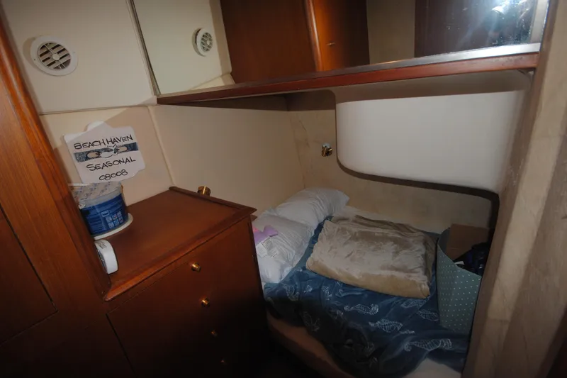 Slide: The Image of 1999 Ocean Yachts 45 Super Sport cabin with cozy bed and wooden storage. - 24
