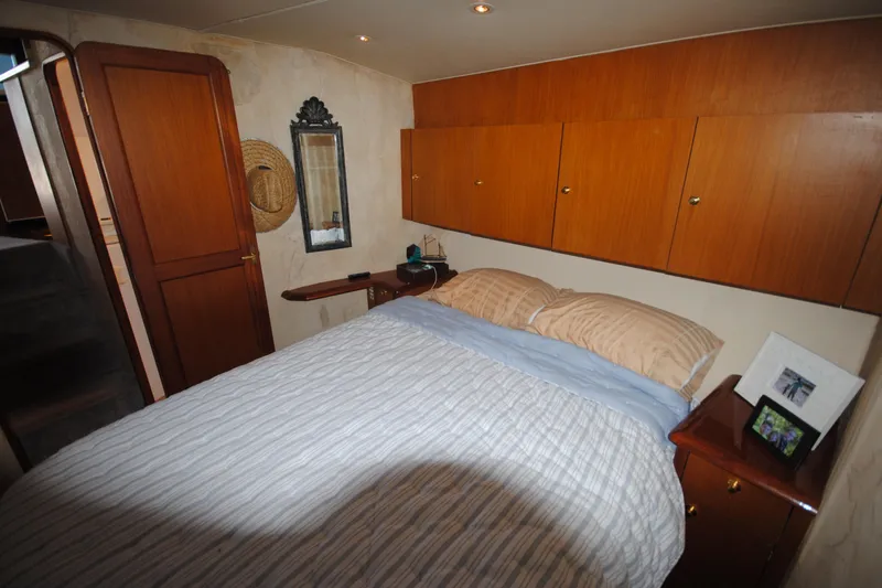 Slide: The Image of Cozy bedroom in 1999 Ocean Yachts 45 Super Sport with wood cabinets and striped bedding. - 27