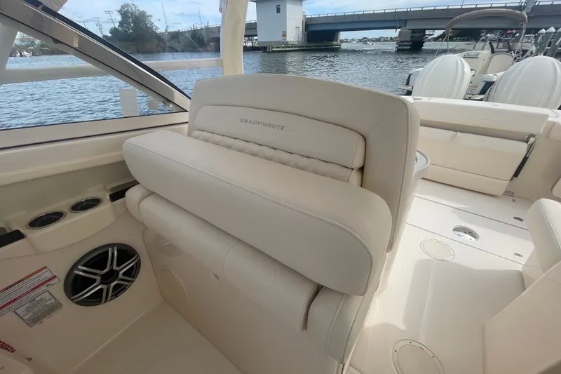 Slide: The Image of 2026 Grady-White Freedom 307 boat interior with beige seating and water view. - 10