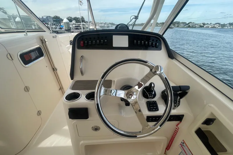 Slide: The Image of Helm of 2026 Grady-White Freedom 307 boat with steering wheel and controls. - 12