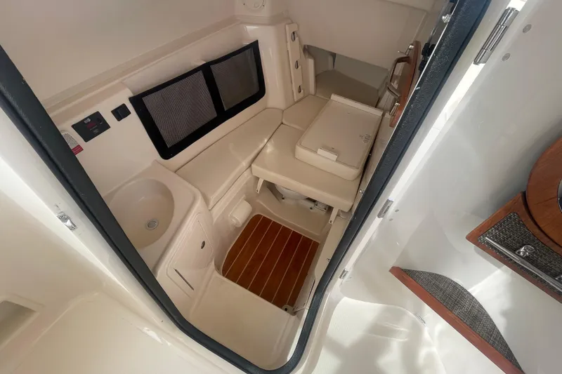 Slide: The Image of 2026 Grady-White Freedom 307 cabin interior with seating, sink, and storage. - 15