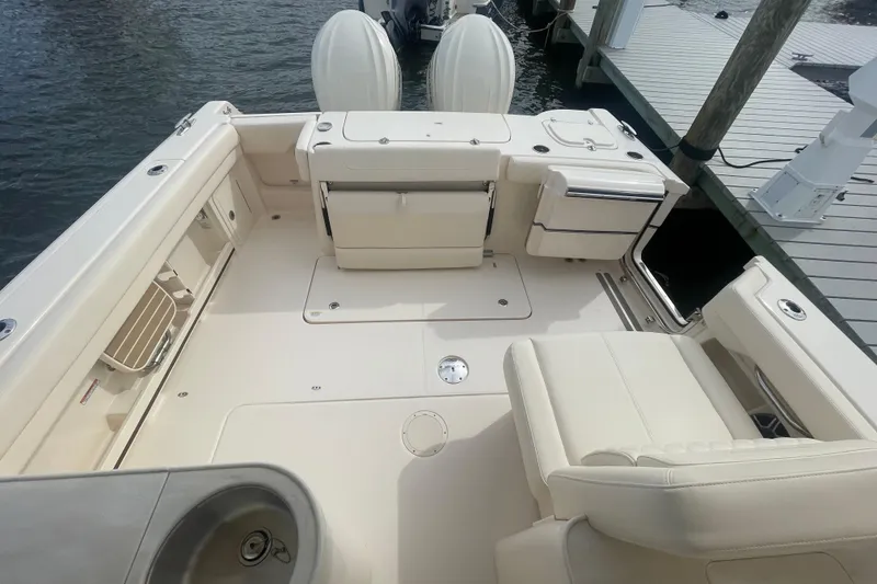 Slide: The Image of 2026 Grady-White Freedom 307 boat interior with seating and deck, docked by the water. - 17