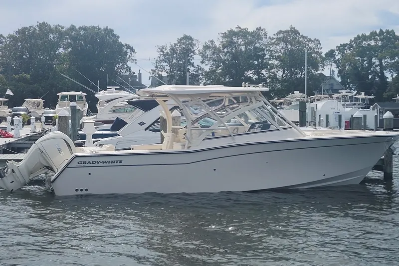Slide: The Image of 2026 Grady-White Freedom 307 boat docked at marina, side view. - 2