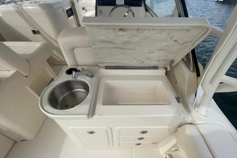 Slide: The Image of 2026 Grady-White Freedom 307 boat interior with sink and storage compartments. - 21