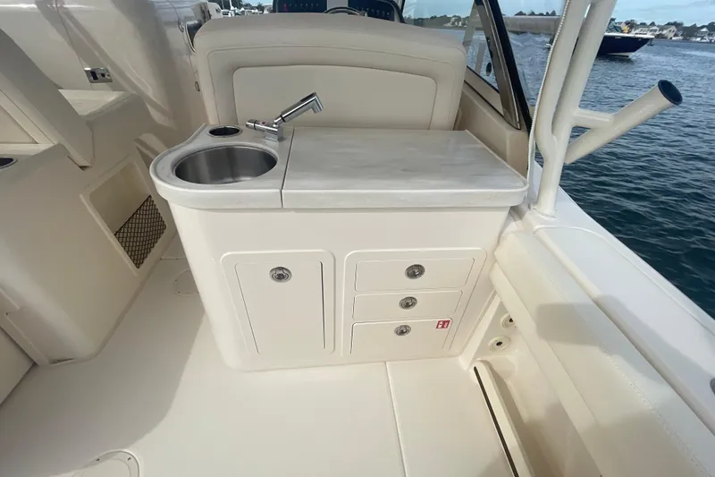 Slide: The Image of 2026 Grady-White Freedom 307 boat interior with sink and storage drawers. - 22