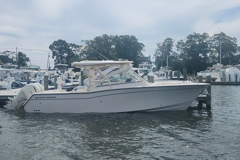 Slide: The Image of 2026 Grady-White Freedom 307 boat docked in a marina, surrounded by other vessels. - 3