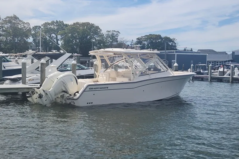 Slide: The Image of 2026 Grady-White Freedom 307 boat docked at marina, clear sky, calm water. - 6