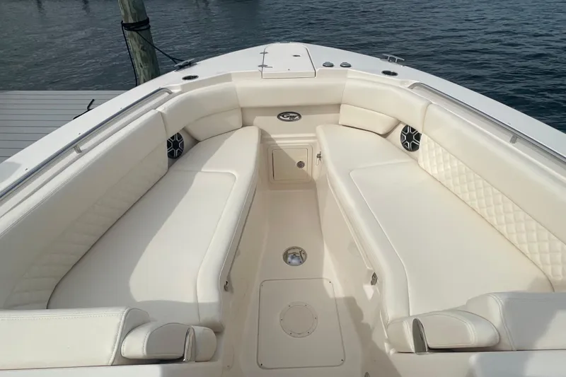 Slide: The Image of 2026 Grady-White Freedom 307 boat interior with white cushioned seating and speakers. - 7