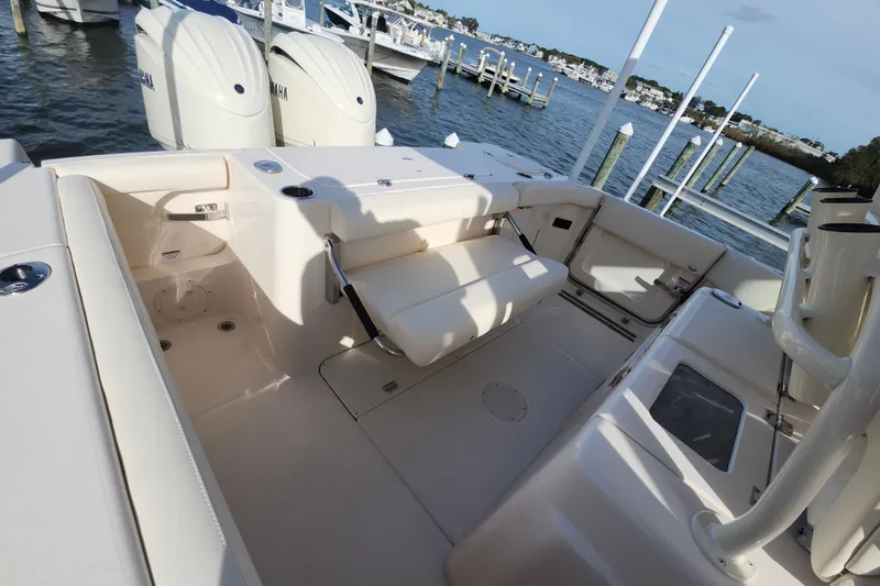 Slide: The Image of 2026 Grady-White Canyon 271 boat interior with seating and Yamaha engines, docked by the water. - 10