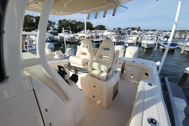 Slide: The Image of 2026 Grady-White Canyon 271 boat interior at marina, featuring helm seats and steering wheel. - 5