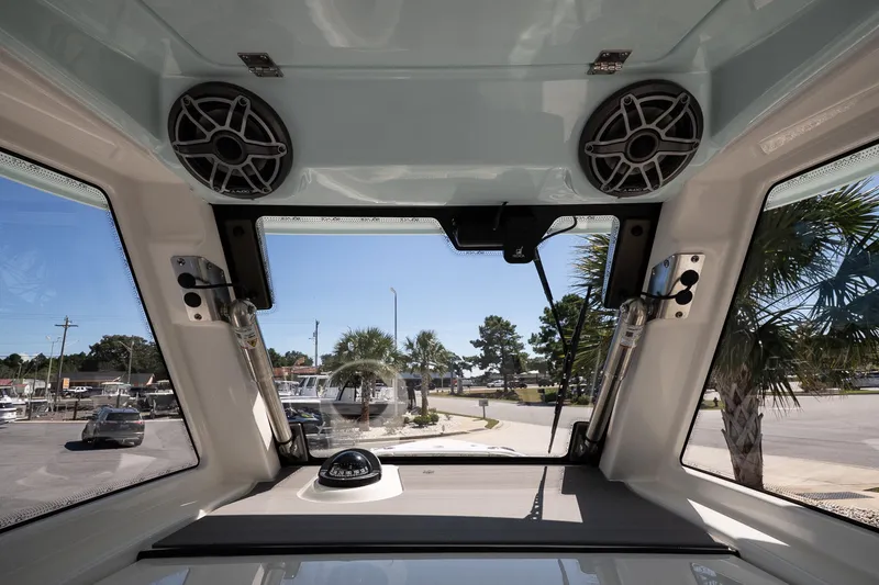 Slide: The Image of 2026 Solace 30 HCS boat interior with seating and speakers, parked near palm trees. - 15