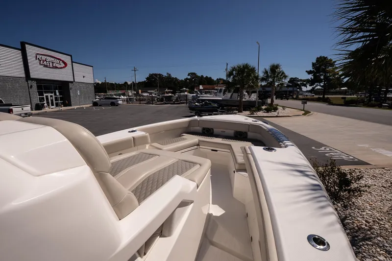 Slide: The Image of 2026 Solace 30 HCS boat with cushioned seating, parked in a marina. - 18