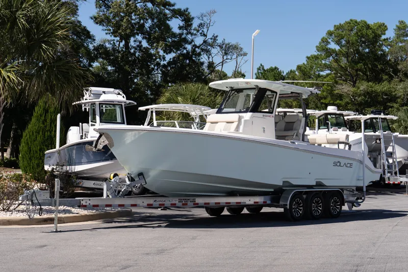 Slide: The Image of 2026 Solace 30 HCS boat on calm water near a coastal marina. - 2
