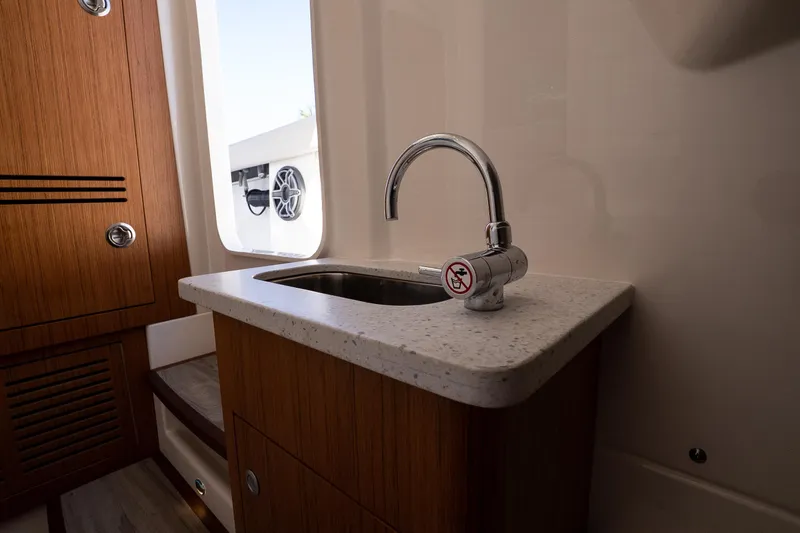 Slide: The Image of 2026 Solace 30 HCS boat interior with sink and wooden cabinetry. - 33