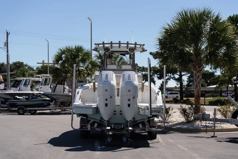 Slide: The Image of 2026 Solace 30 HCS boat on trailer, parked outdoors with trees in background. - 5