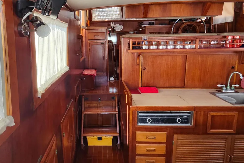 Slide: The Image of Interior of 1988 Sundowner Tug 30, featuring wooden cabinetry and nautical decor. - 13