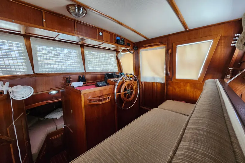 Slide: The Image of Interior of 1988 Sundowner Tug 30 with wooden helm and seating area. - 18