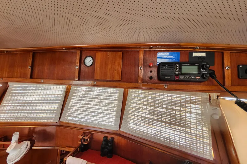Slide: The Image of 1988 Sundowner Tug 30 interior with wooden paneling, radio equipment, and window blinds. - 25