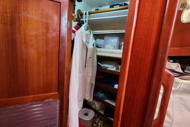 Slide: The Image of Interior of 1988 Sundowner Tug 30 with wooden closet and hanging clothes. - 26