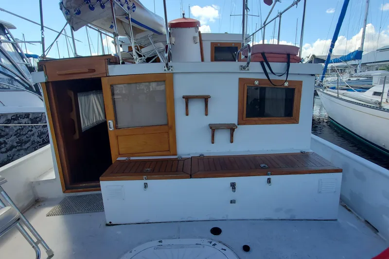 Slide: The Image of 1988 Sundowner Tug 30 boat deck with wooden accents and marina backdrop. - 6