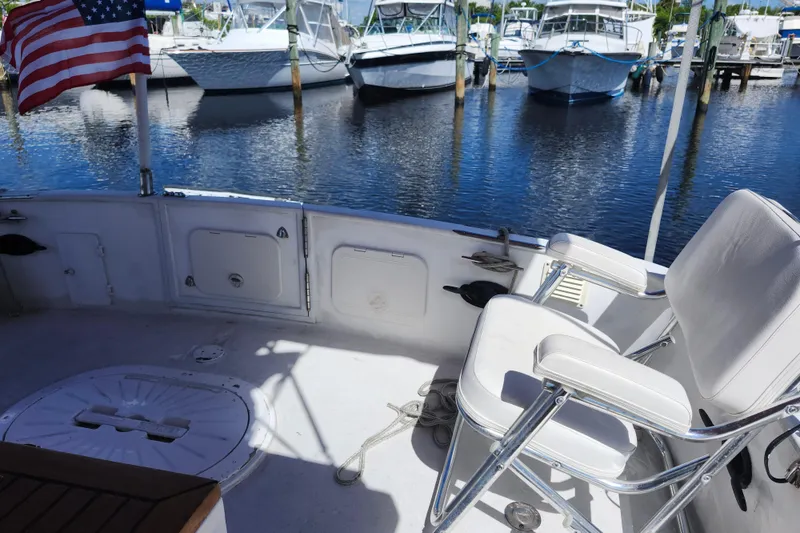Slide: The Image of 1988 Sundowner Tug 30 boat interior with American flag, docked near other boats. - 7