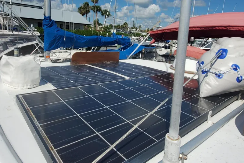 Slide: The Image of 1988 Sundowner Tug 30 with solar panels on deck, docked in a marina under blue skies. - 9