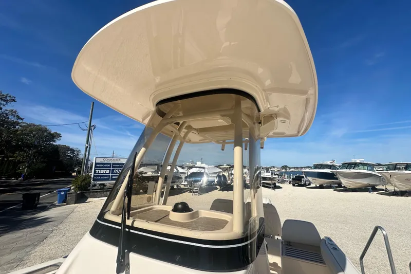 Slide: The Image of 2026 Grady-White Fisherman 216 boat with T-top, displayed outdoors under clear blue sky. - 13