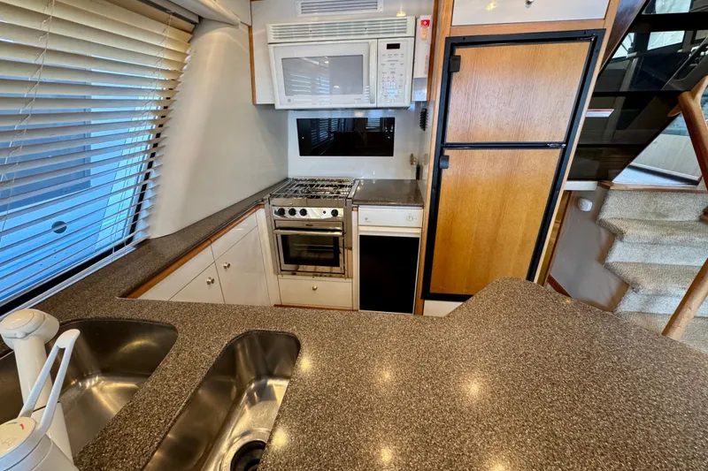 Slide: The Image of 2000 Bayliner 4788 Pilot House Motoryacht kitchen with modern appliances and granite countertops. - 17